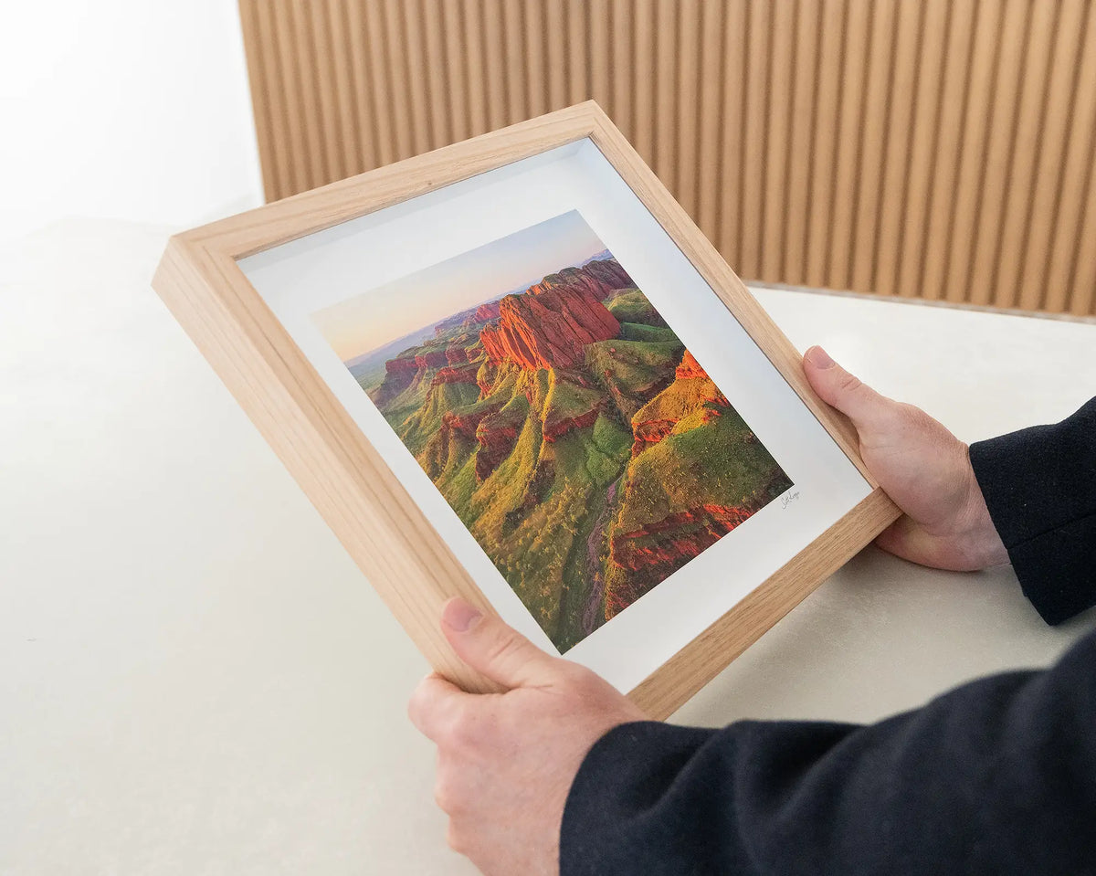 Kimberley Spirit. Sunset over East Kimberley small framed print with timber frame being hand held.