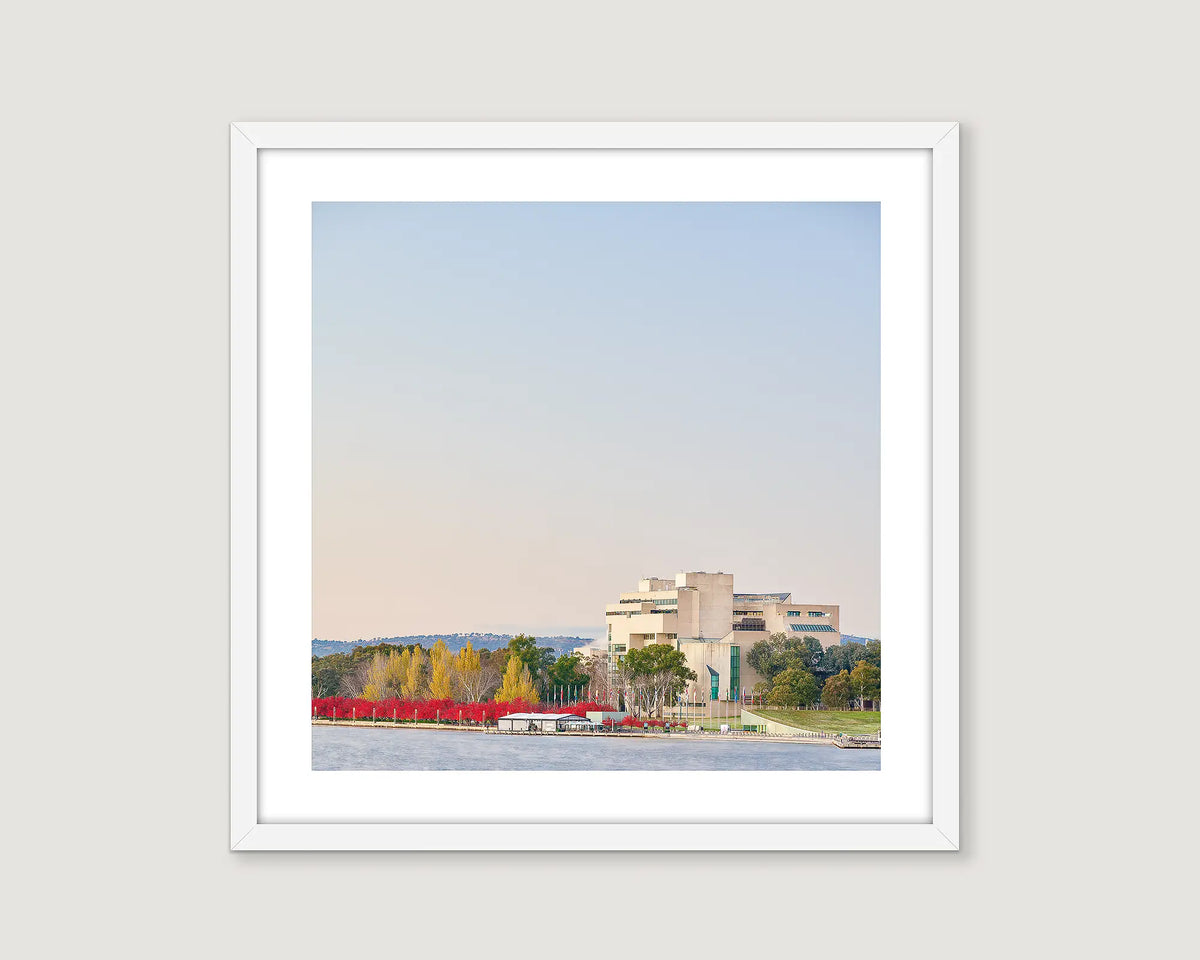 Framed wall art print of trees turning red in autumn and The High Court around Lake Burley Griffin. 