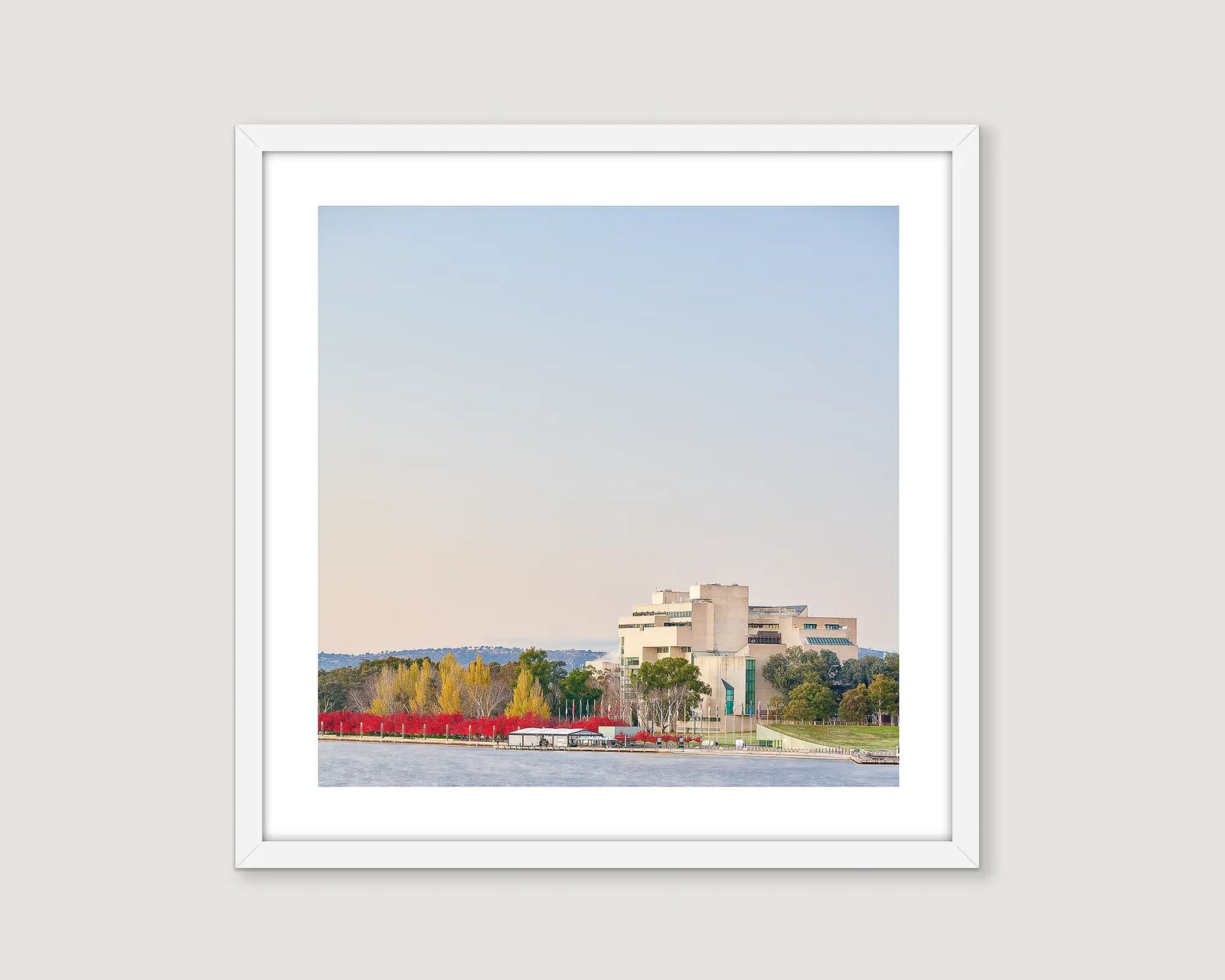 Framed wall art print of trees turning red in autumn and The High Court around Lake Burley Griffin. 
