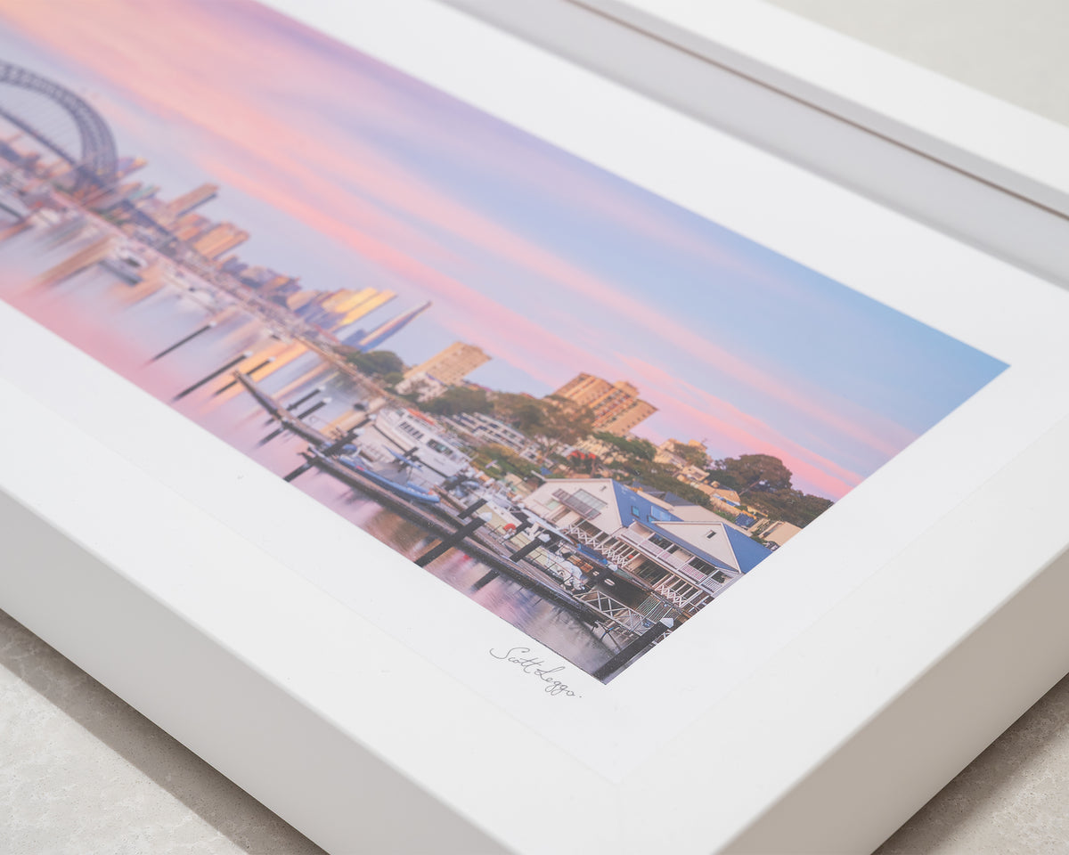 Lavender Sunrise. Pink sunrise over Sydney Harbour Bridge and Lavender Bay, with white frame corner close-up details.