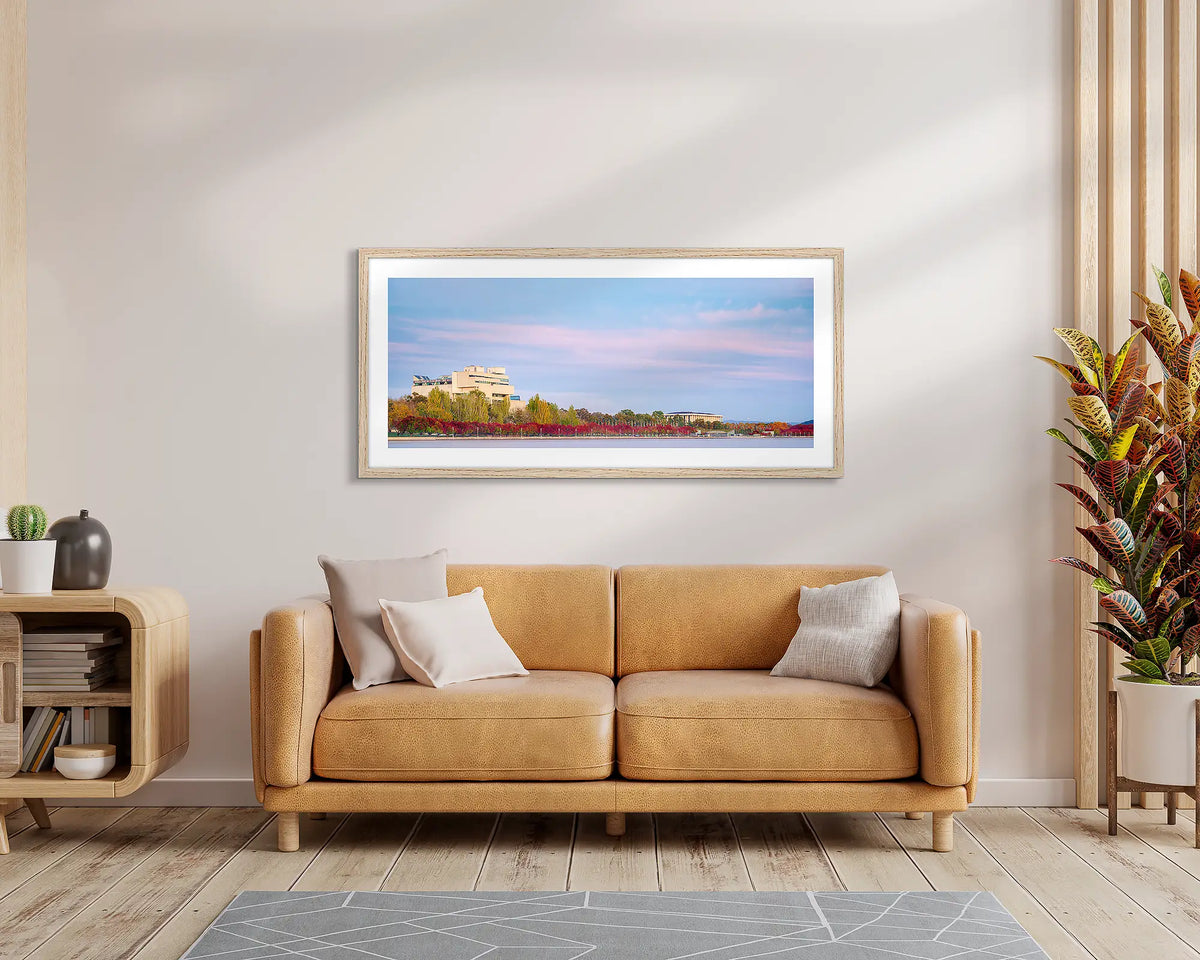 Law and Books. Framed wall art print of the High Court and National Library, with a timber frame, hung above a leather couch.
