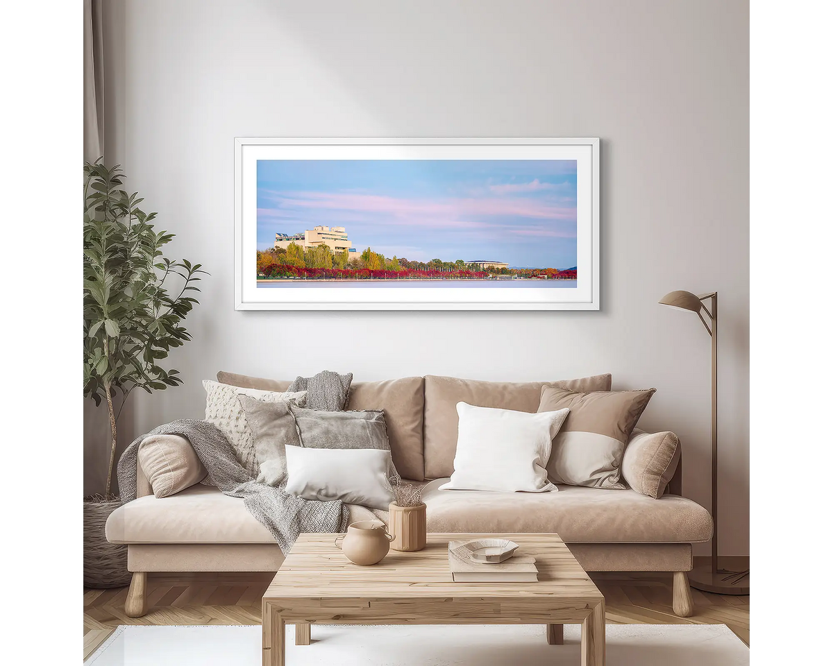 Law and Books. Framed wall art print of the High Court and National Library, with a white frame, hung above a couch.