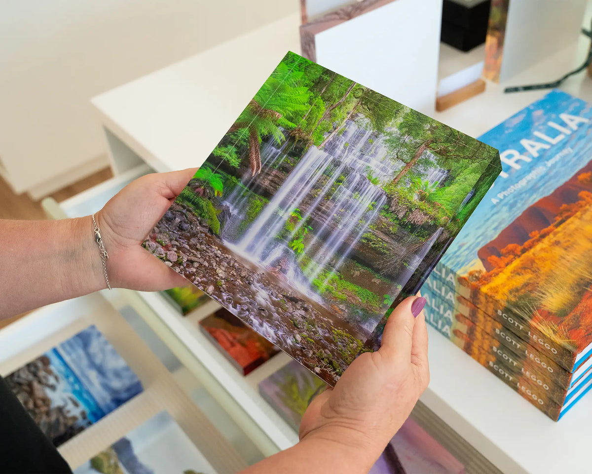 Layers. Tasmanian waterfall 19cm acrylic block, held in hands in gallery.