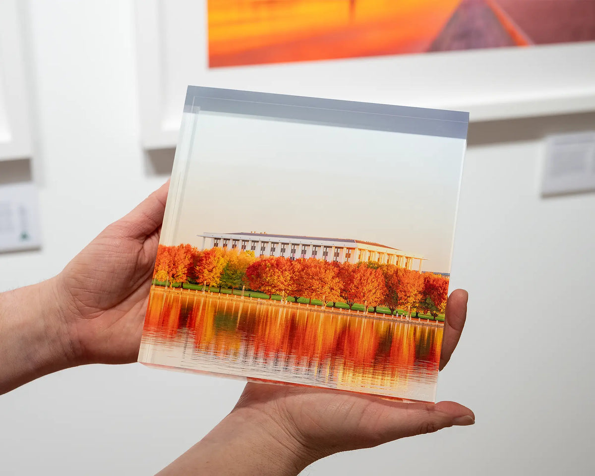 Library Reds. Acrylic block of the National Library of Australia, Canberra, being held in hands.