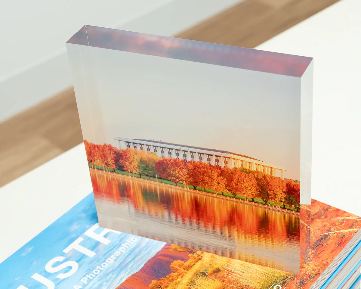Library Reds. Acrylic block of the National Library of Australia in Autumn, sitting on books.