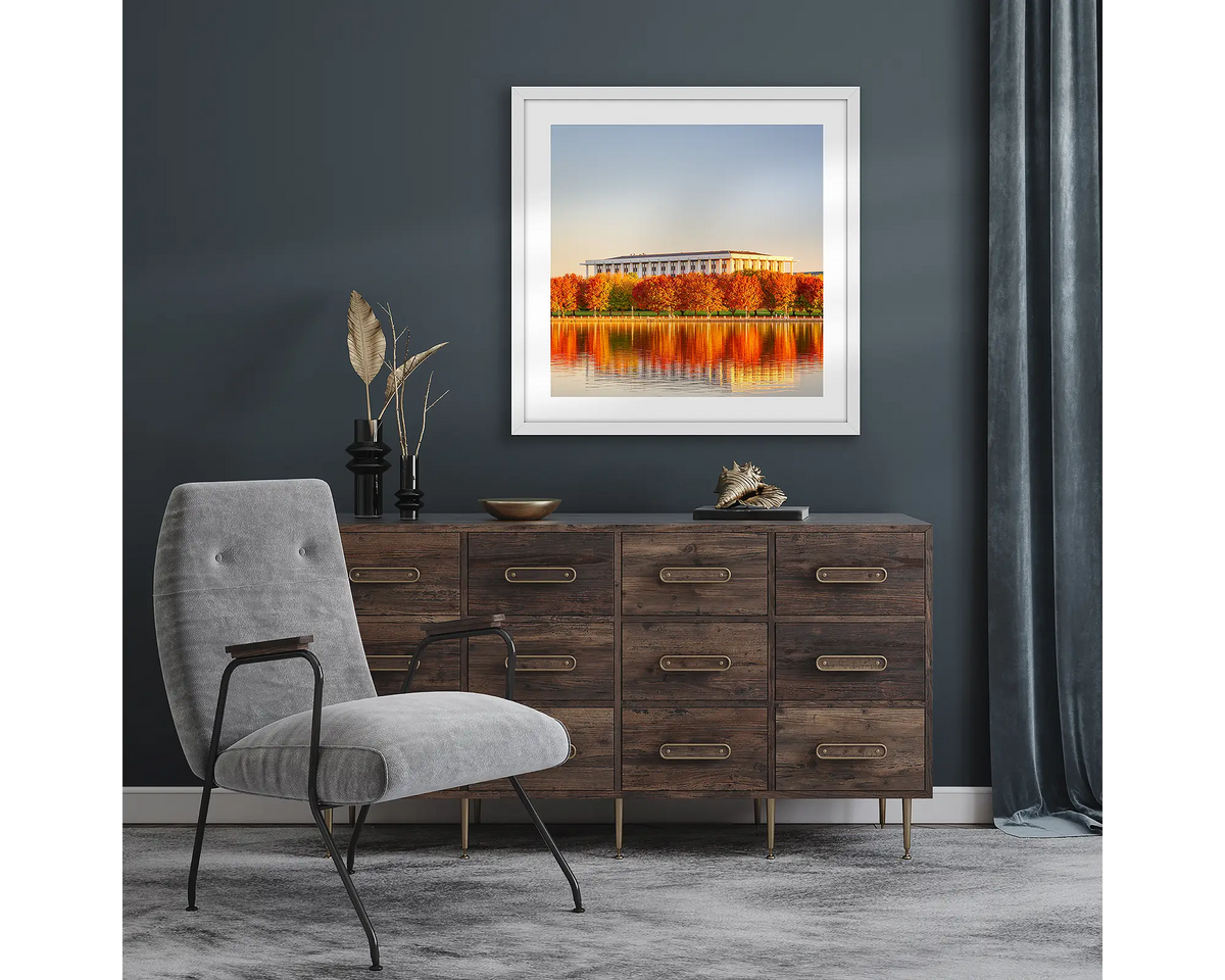 Library Reds. Wall art print with white frame of autumn sunset over National Library of Australia, Canberra, hung in a room with dark walls.
