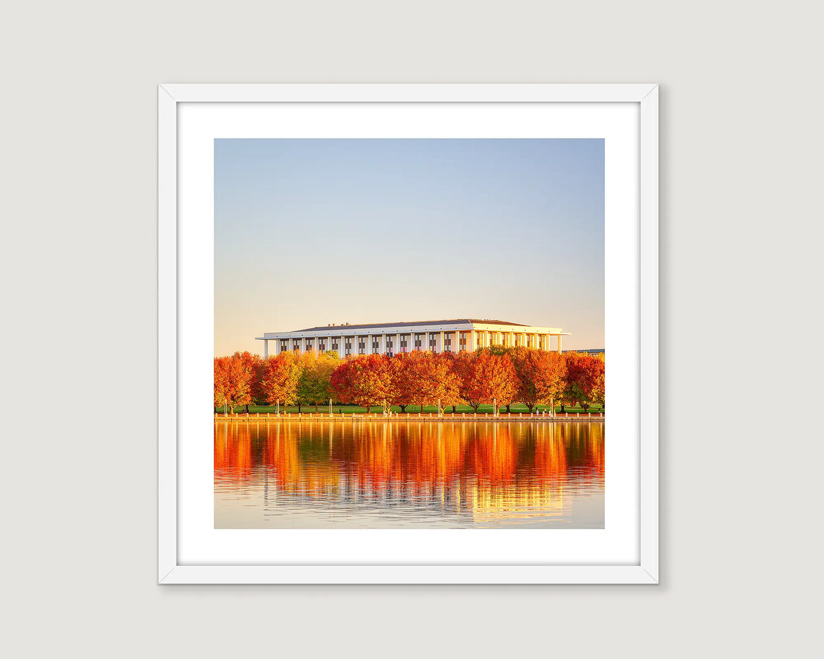 Framed wall art print of the National Library of Australia, with trees turning red in autumn, alongside Lake Burley Griffin. 