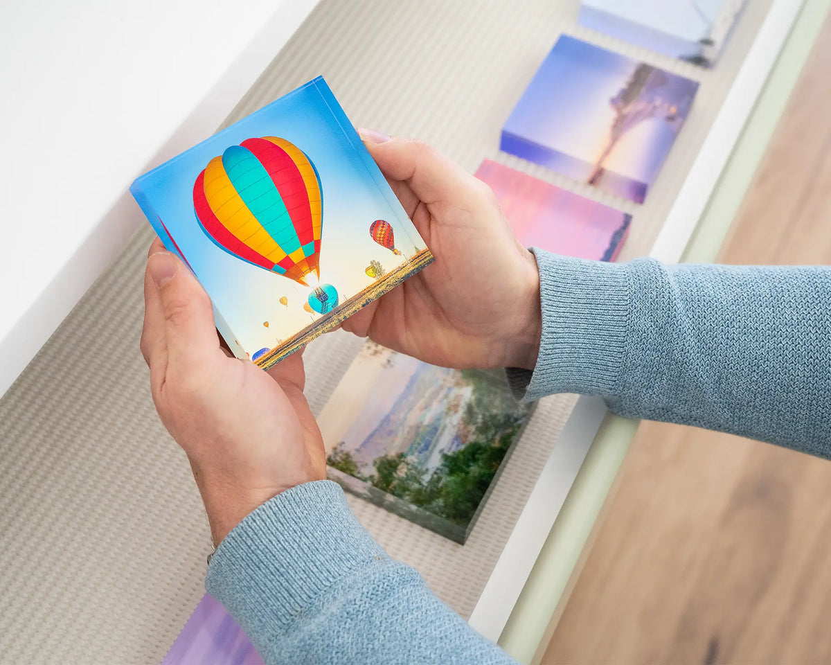 Lift. Acrylic block of hot air balloons being hand held.