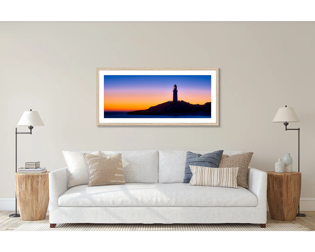Light beyond. Wall art print of the Rottnest Island Lighthouse framed with a Tasmanian Oak frame and hung above a couch. 