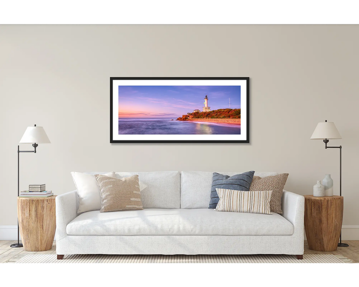 Light Me Up. Wall art print of Point Lonsdale lighthouse, framed with black frame, hung above couch.