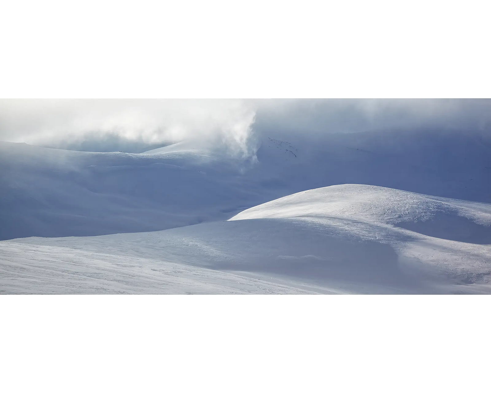 Light Show. Light filtering through clouds, over a snow covered Snowy River and main range, Kosciuszko National Park. 