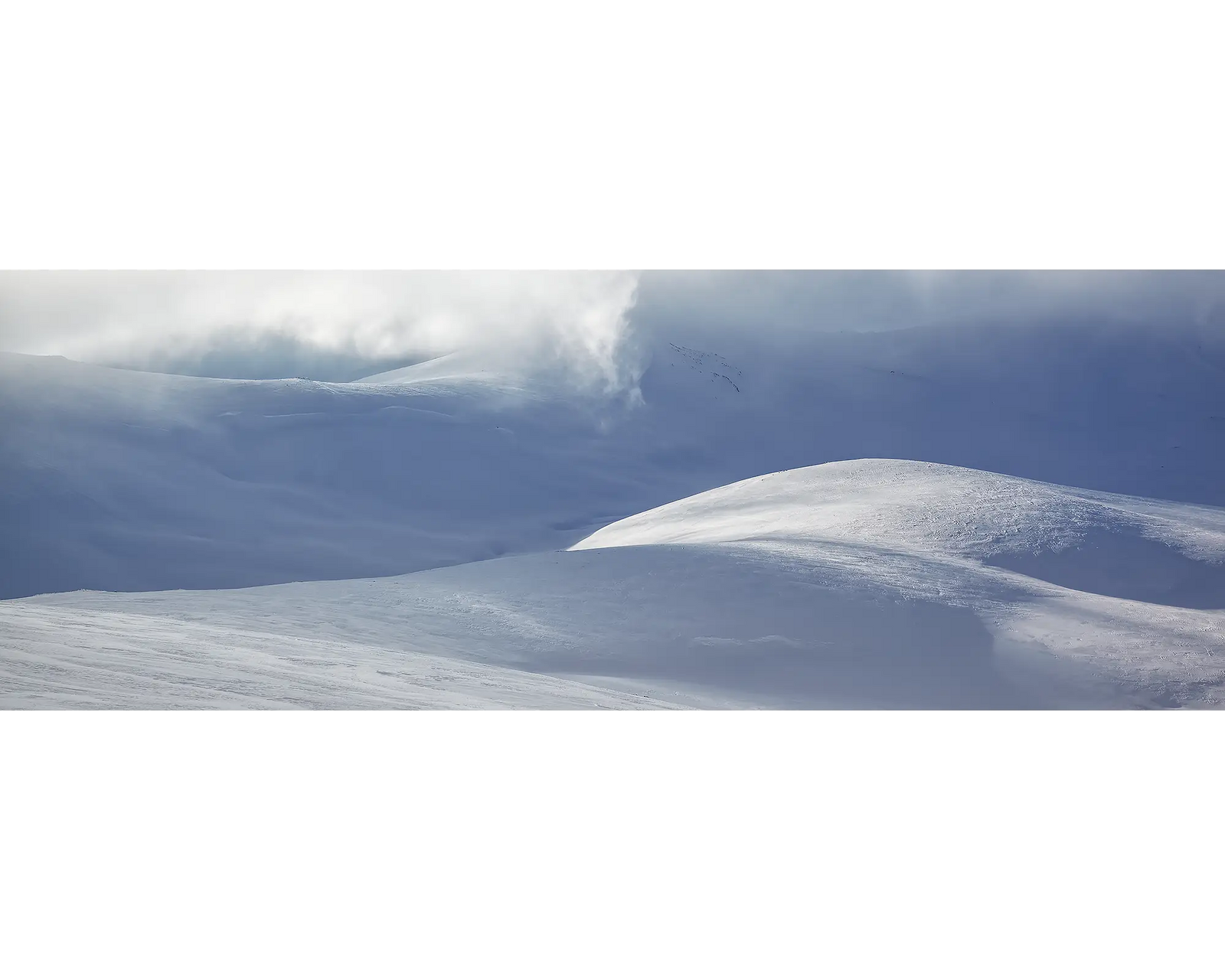 Light Show. Light filtering through clouds over snow covered main range, Kosciuszko National Park.