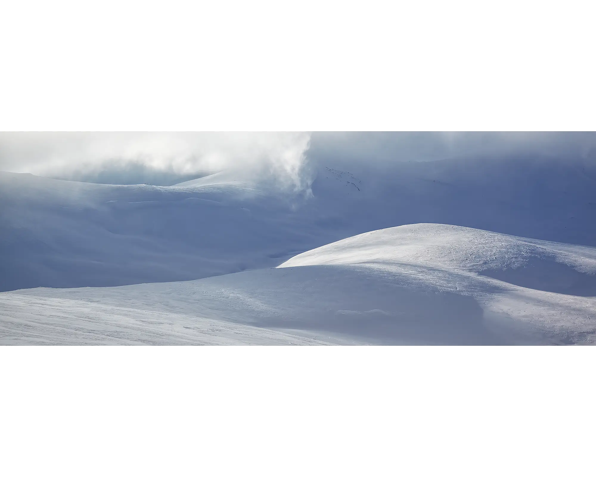 Light Show. Light filtering through clouds over snow covered main range, Kosciuszko National Park.