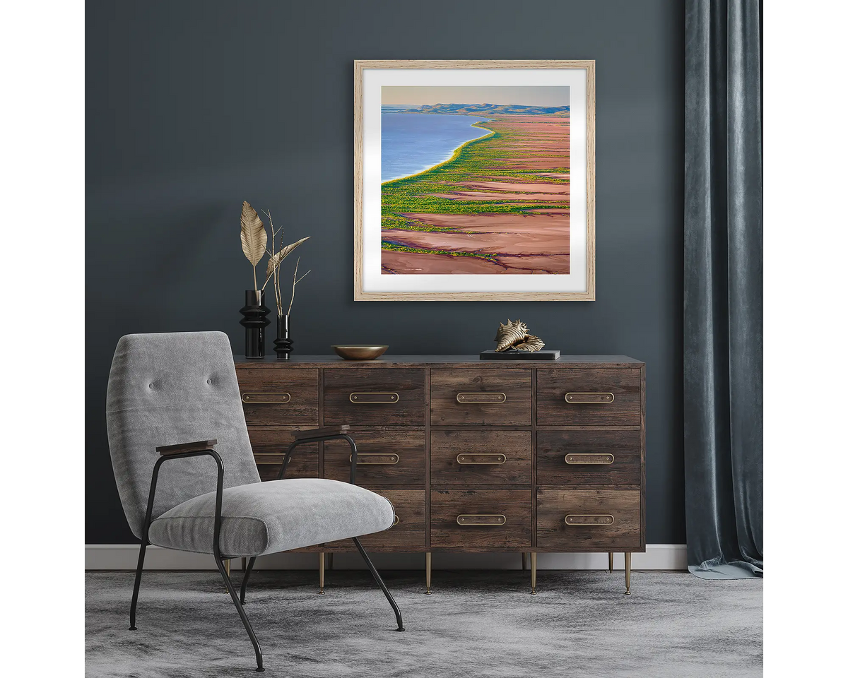 Lighting the Gulf. Wall art print with a timber frame of sunset over Cambridge Gulf mudflats, The Kimberley, hung in a room with dark walls.