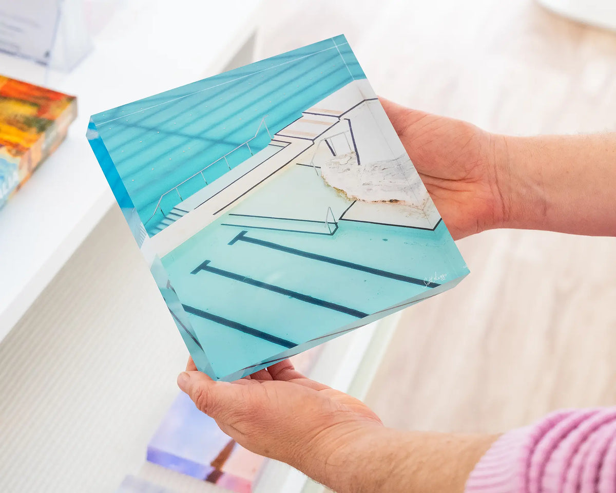 Lines. Acrylic block of Bondi Icebergs Ocean Baths, Sydney, held in hands.