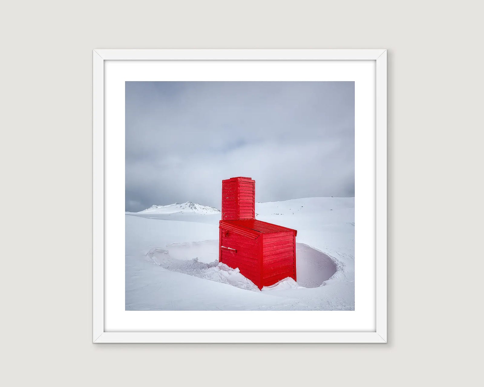 Wall art print of Cootapatamba Hut painted red and nestled in deep snow on a cloudy day. 