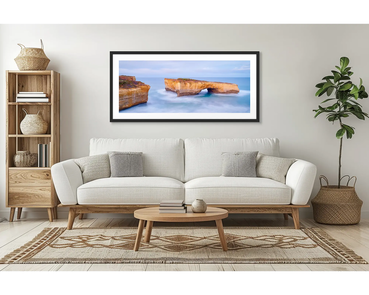 London Bridge. Great Ocean Road wall art print, framed with a black frame and hung above a couch in a lounge room. 