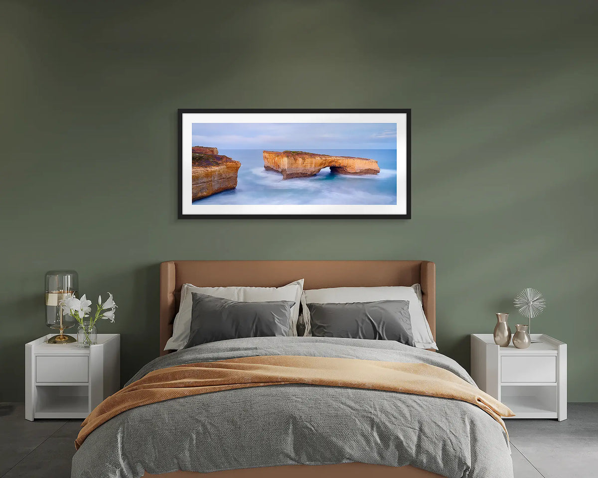 London Bridge. Great Ocean Road wall art print, framed with a black frame and hung on a bedroom wall. 