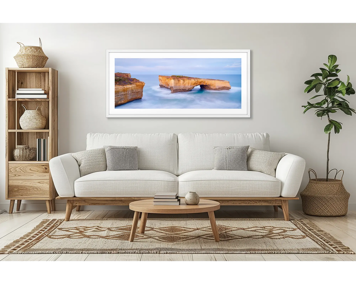 London Bridge. Great Ocean Road wall art print, framed with a white frame and hung above a couch in a lounge room. 