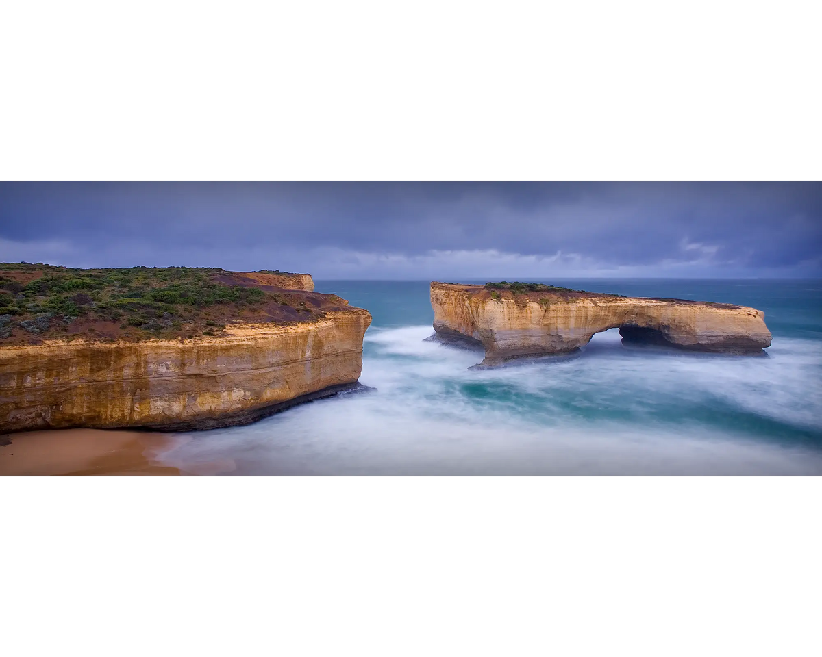 Rough waters and stormy skies over London Arch, Port Campbell National Park, Victoria. 