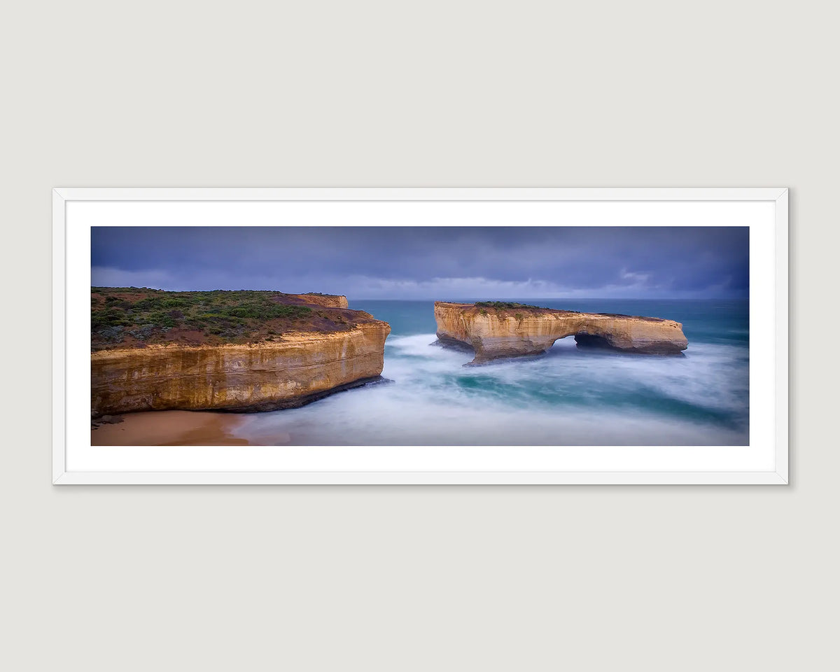 Framed photograph of a bridge rock formation in a stormy sea.