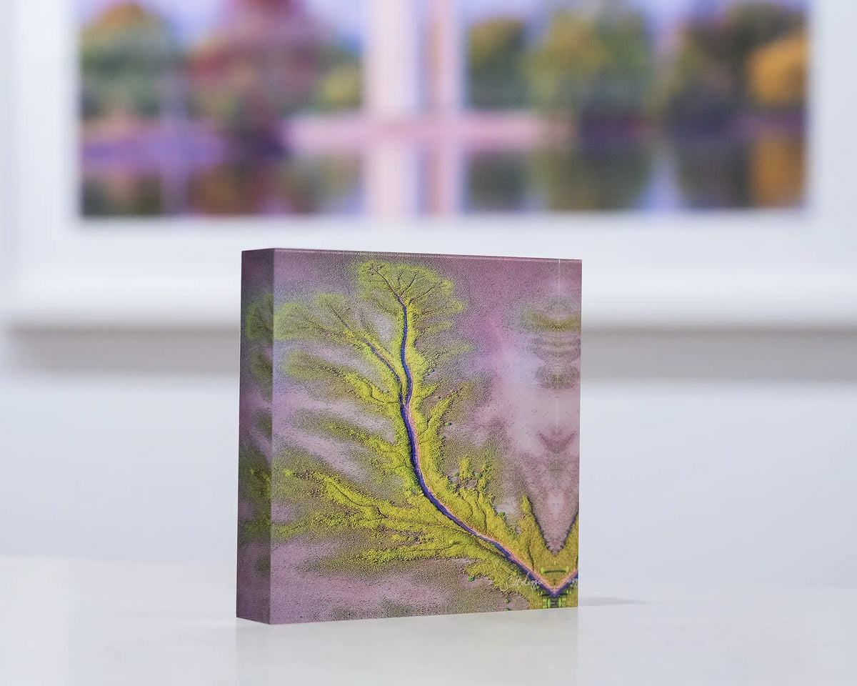 Lumination. Acrylic block King River, The Kimberley, on gallery desk with complimentary artwork in background.