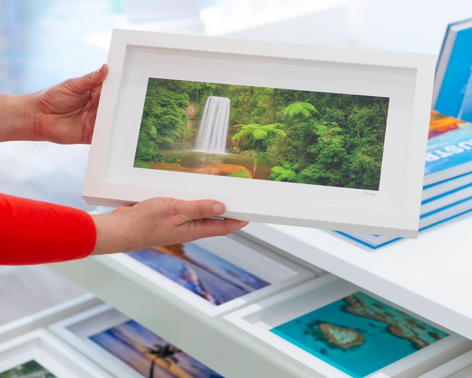 Framed wall art print of a tropical rainforest and water cascading down Milla Milla falls into a rock pool.