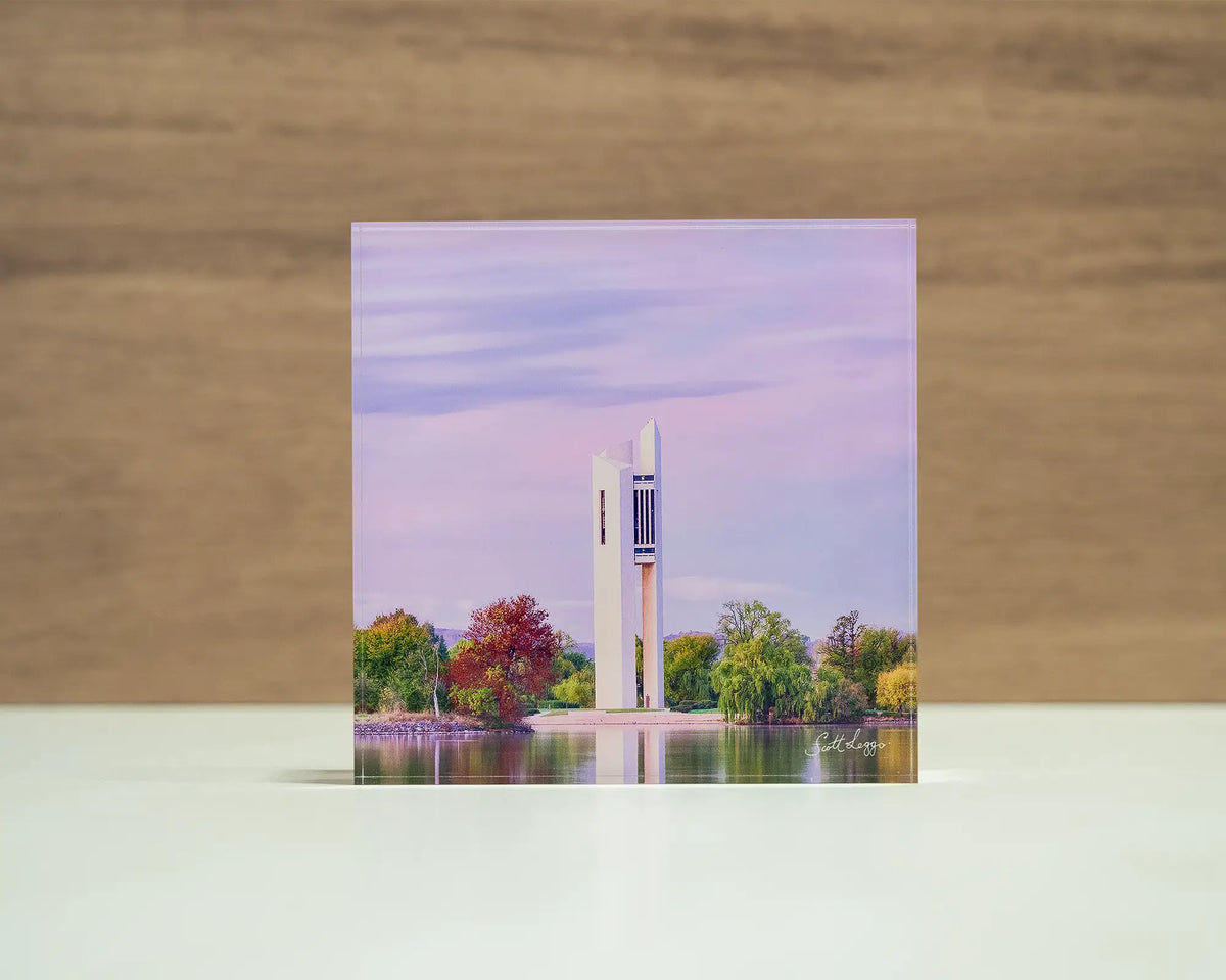 Magenta Dawn. Acrylic block of sunrise at National Carillon Canberra, front view sitting on a desk.