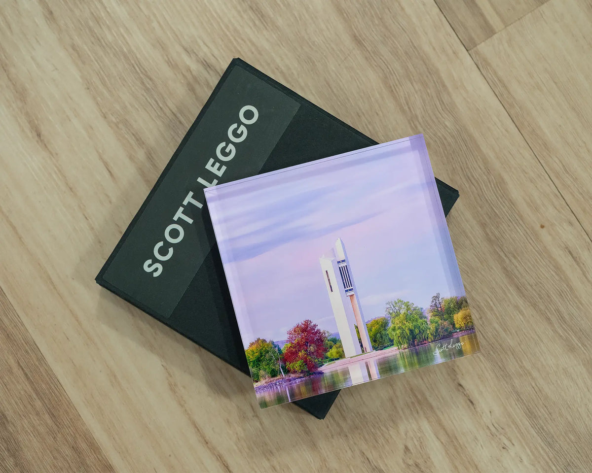 Magenta Dawn. Acrylic block of sunrise at National Carillon Canberra, laying flat on a gift box.