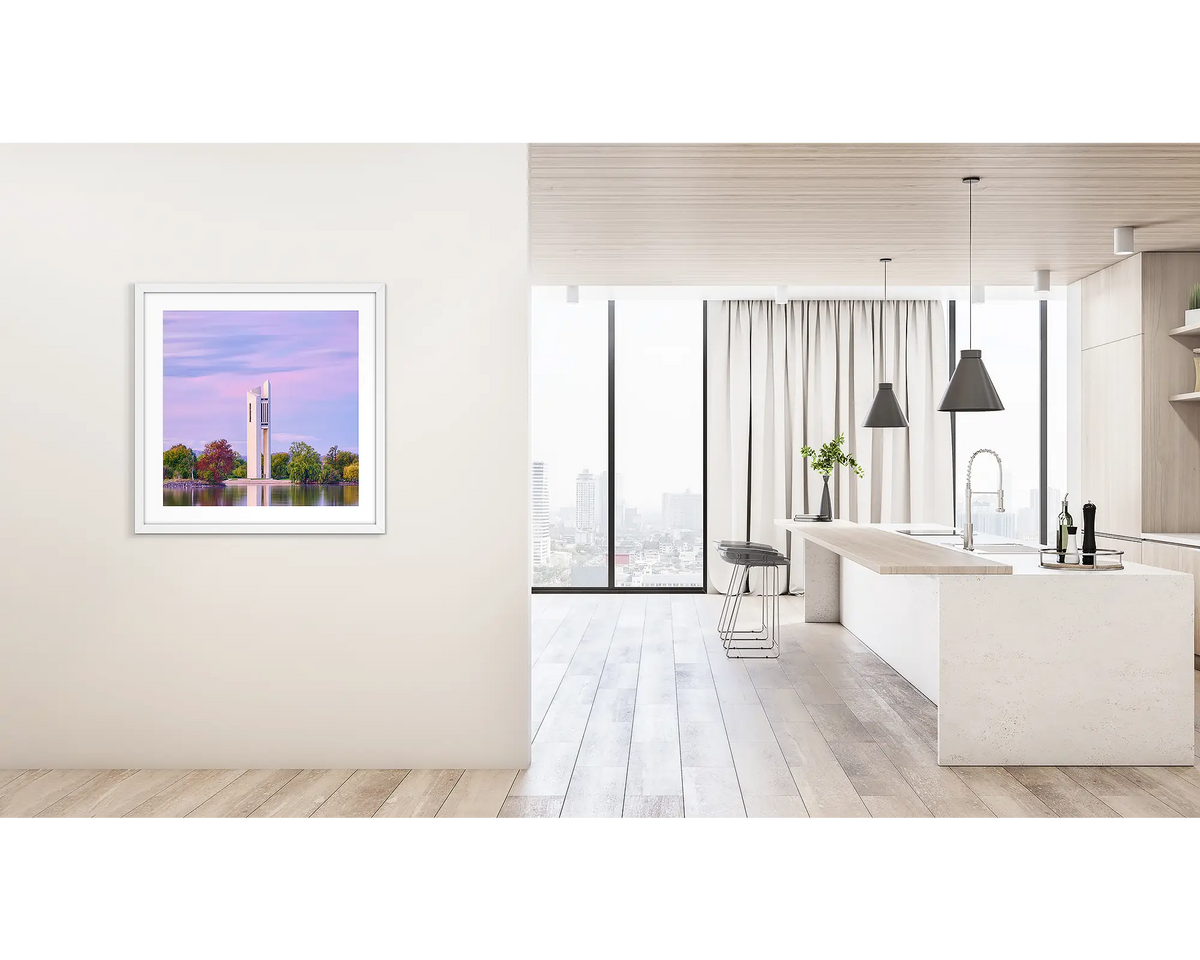 Magenta Dawn. Framed wall art print of the National Carillon, Canberra, with a white frame hung on a hallway wall.