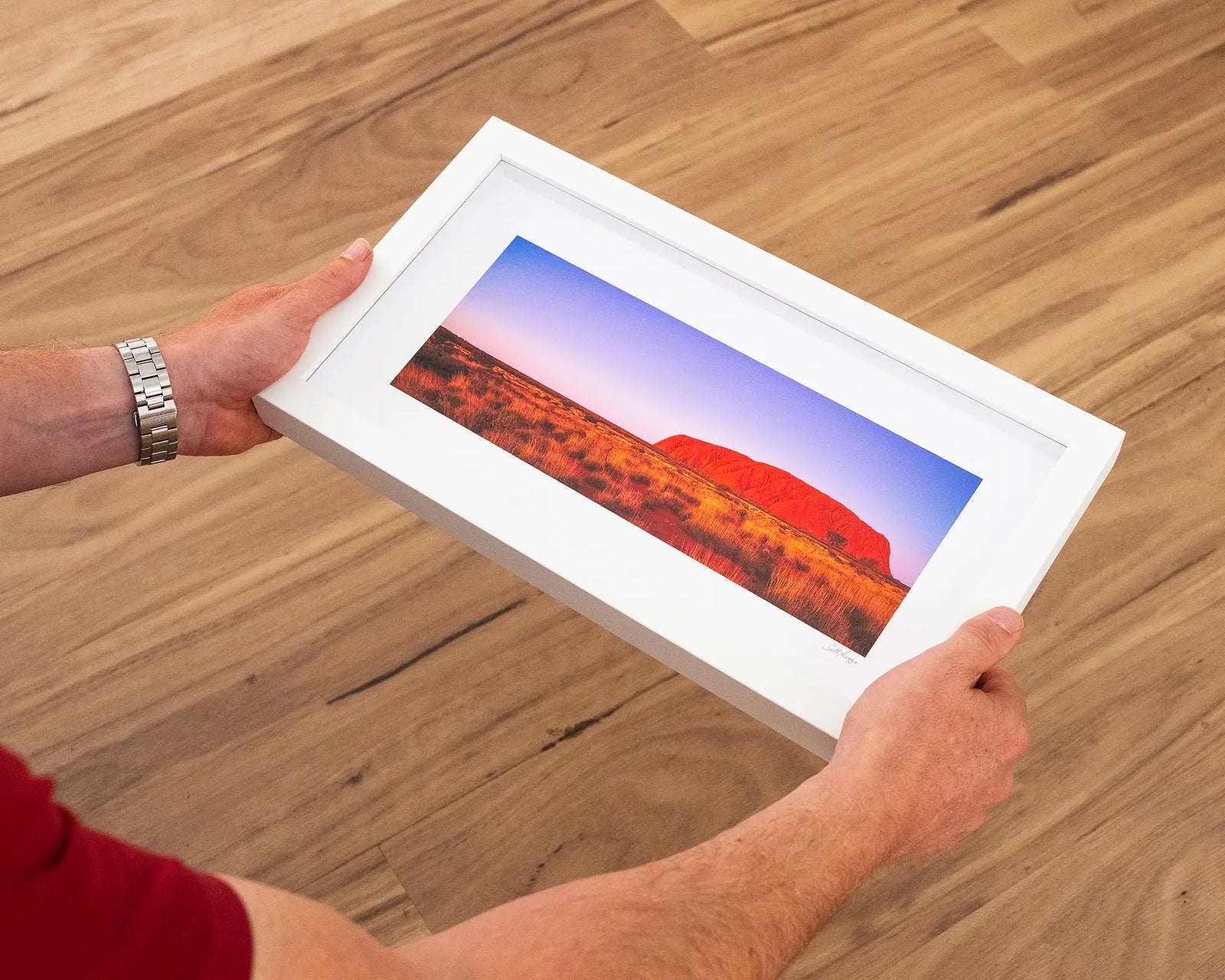 Framed artwork of Uluru with a purple sky at sunset.