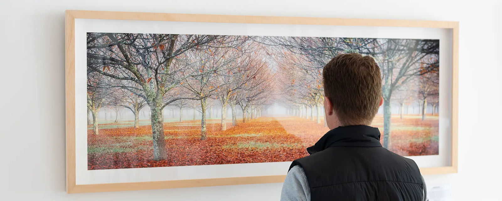 Man looking at Scott Leggo artwork titled Emergent, hung on wall.