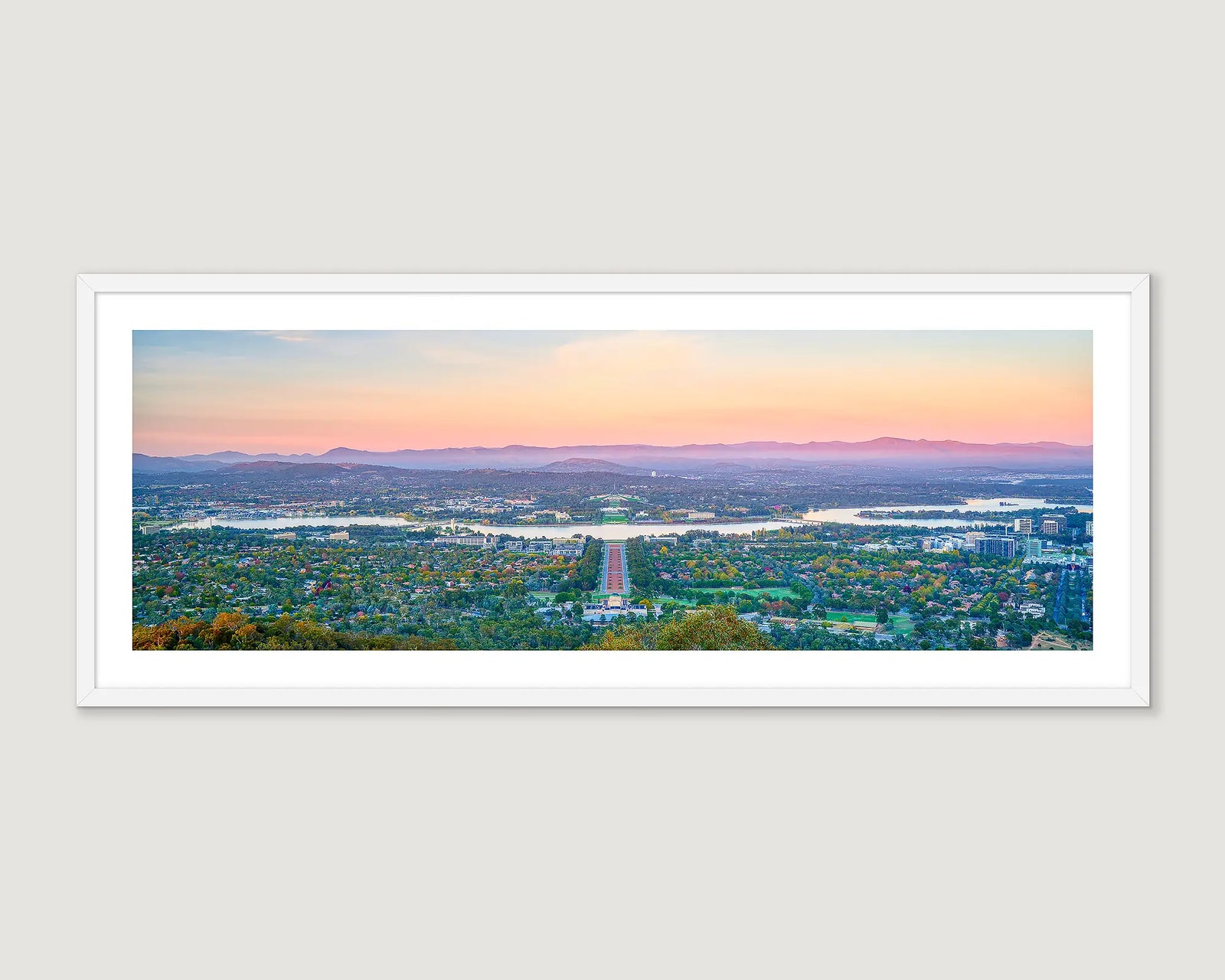 Framed photograph of a view of Canberra and the Brindabella Ranges at sunrise.