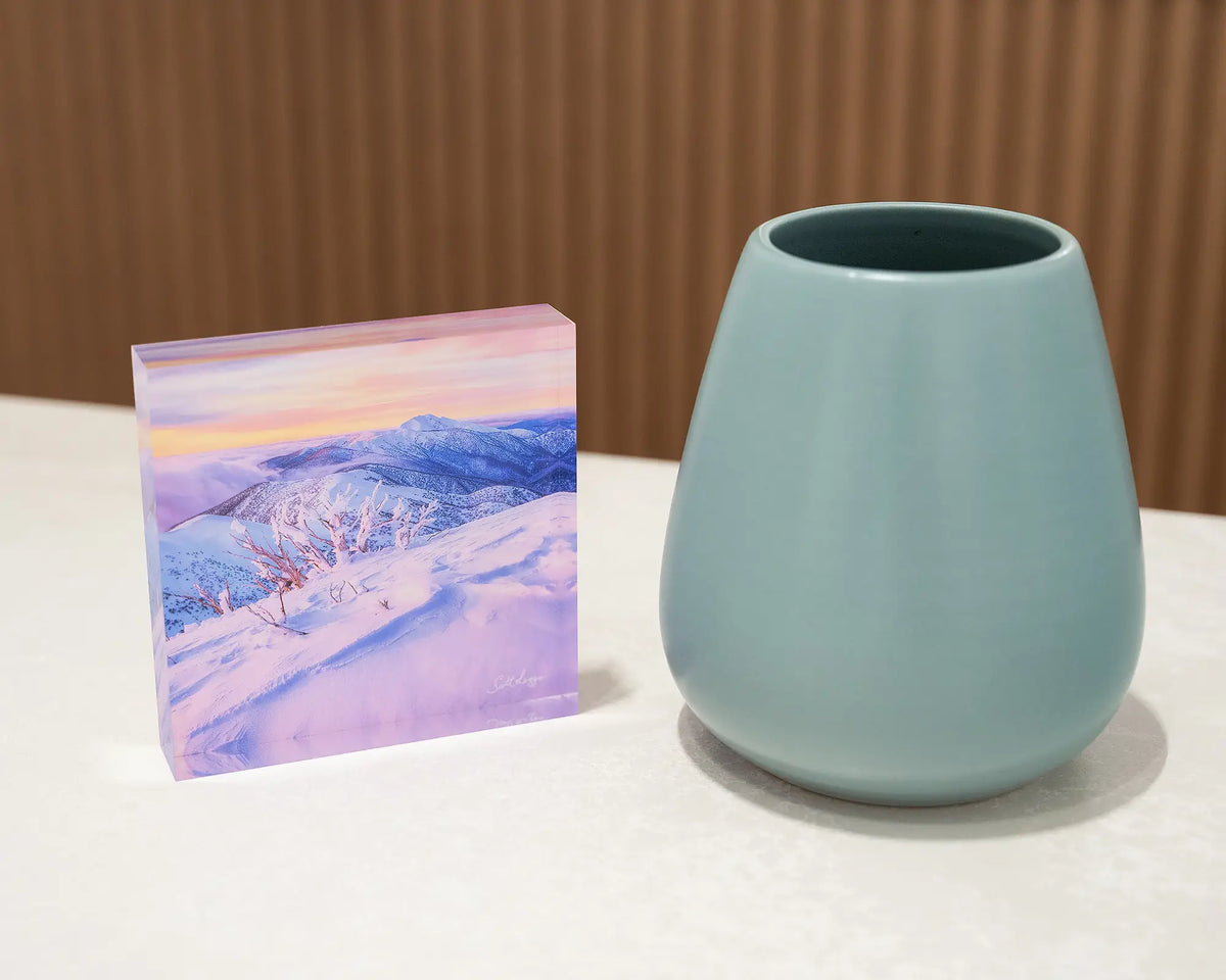 Memories Of Winter. Acrylic block of sunset light over Mount Feathertop, on desk styled with a small vase.