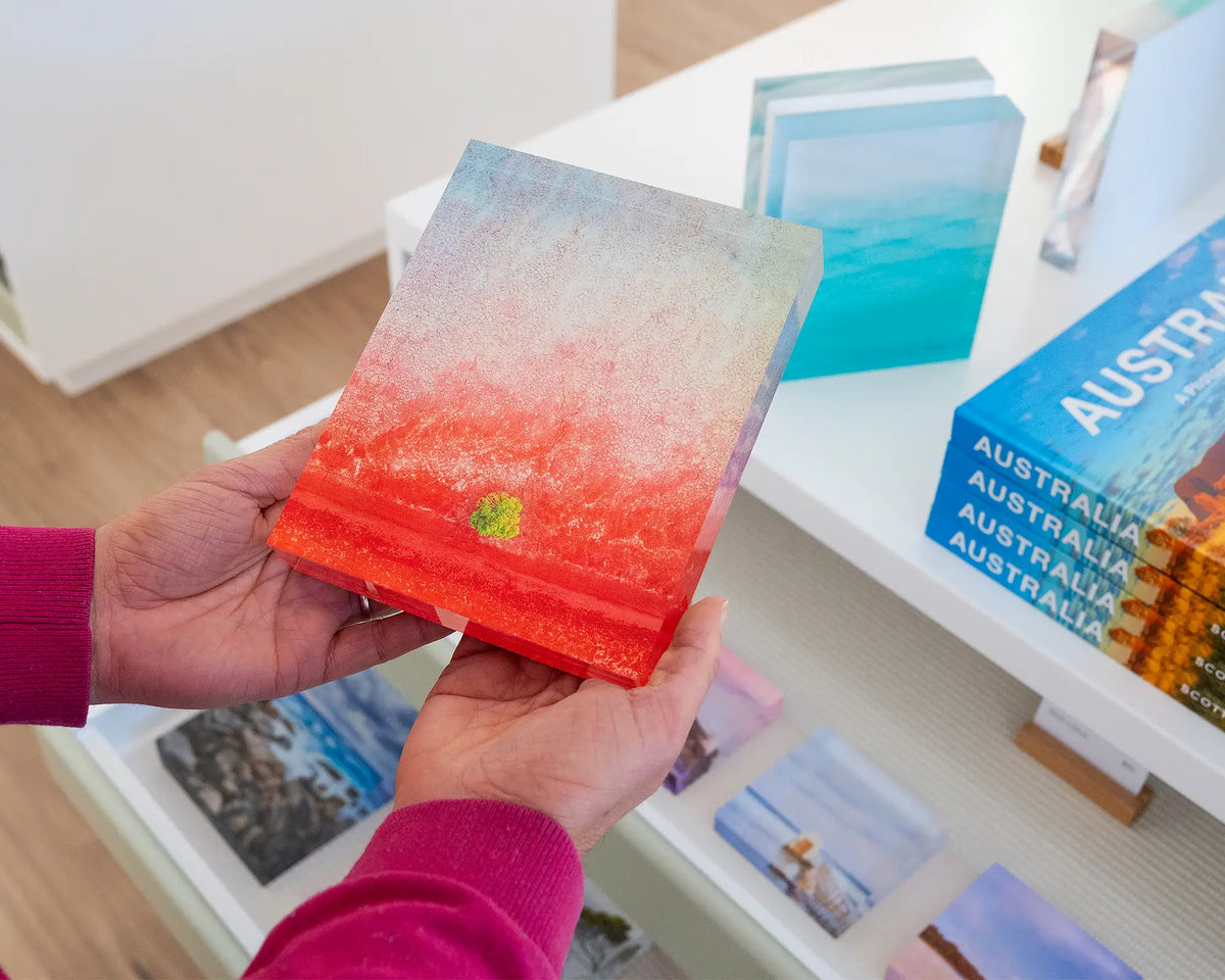 Mini. Acrylic block aerial artwork of Broome, The Kimberley, hand held in gallery with more coastal acrylic blocks.