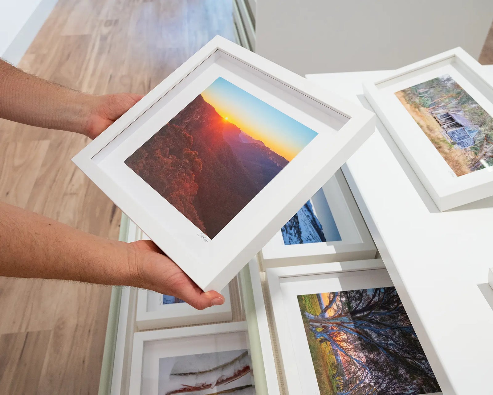 Framed photograph of a mountain region and a golden sunrise.