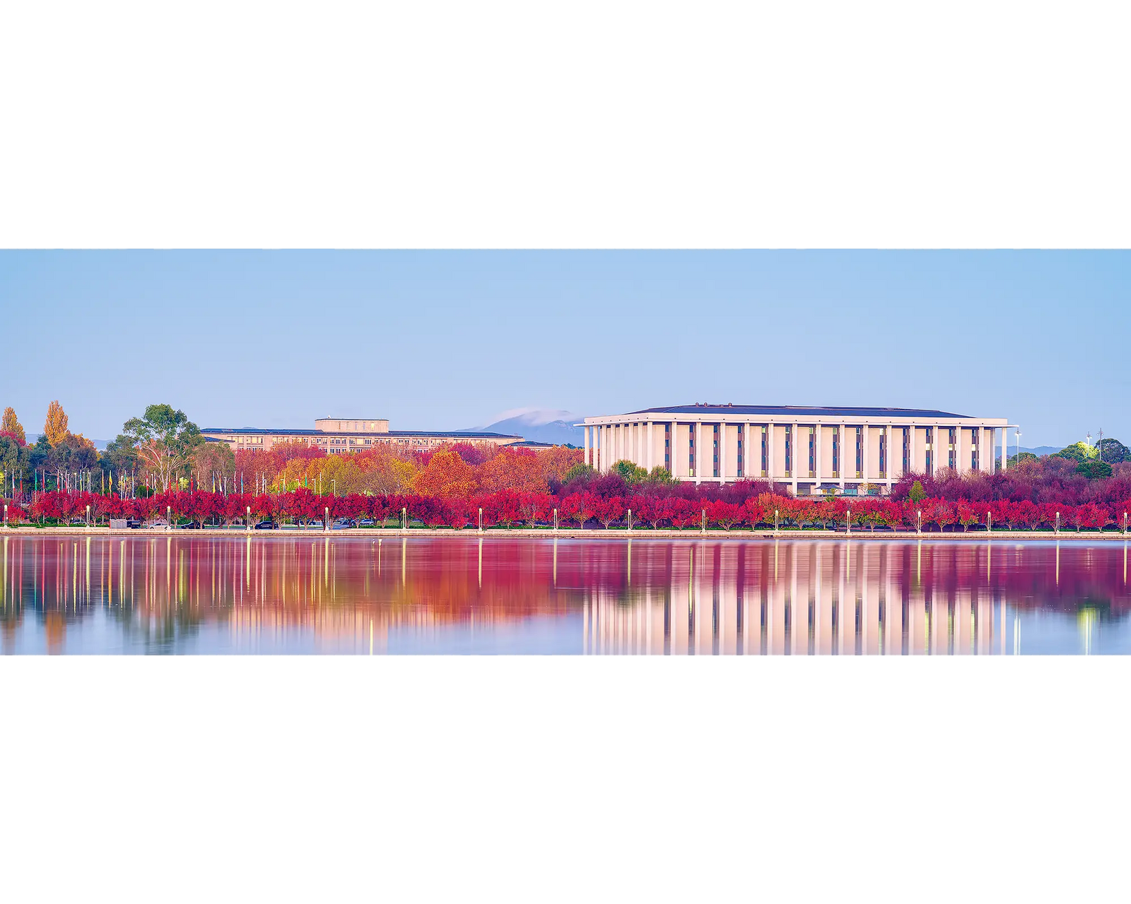 Morning Reds. National Library Of Australia at sunrise with reflected red autumn colours in the water.