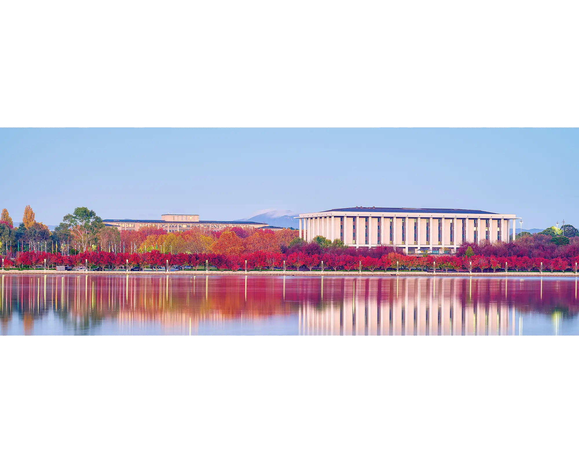 Morning Reds. National Library Of Australia at sunrise with reflected red autumn colours in the water.