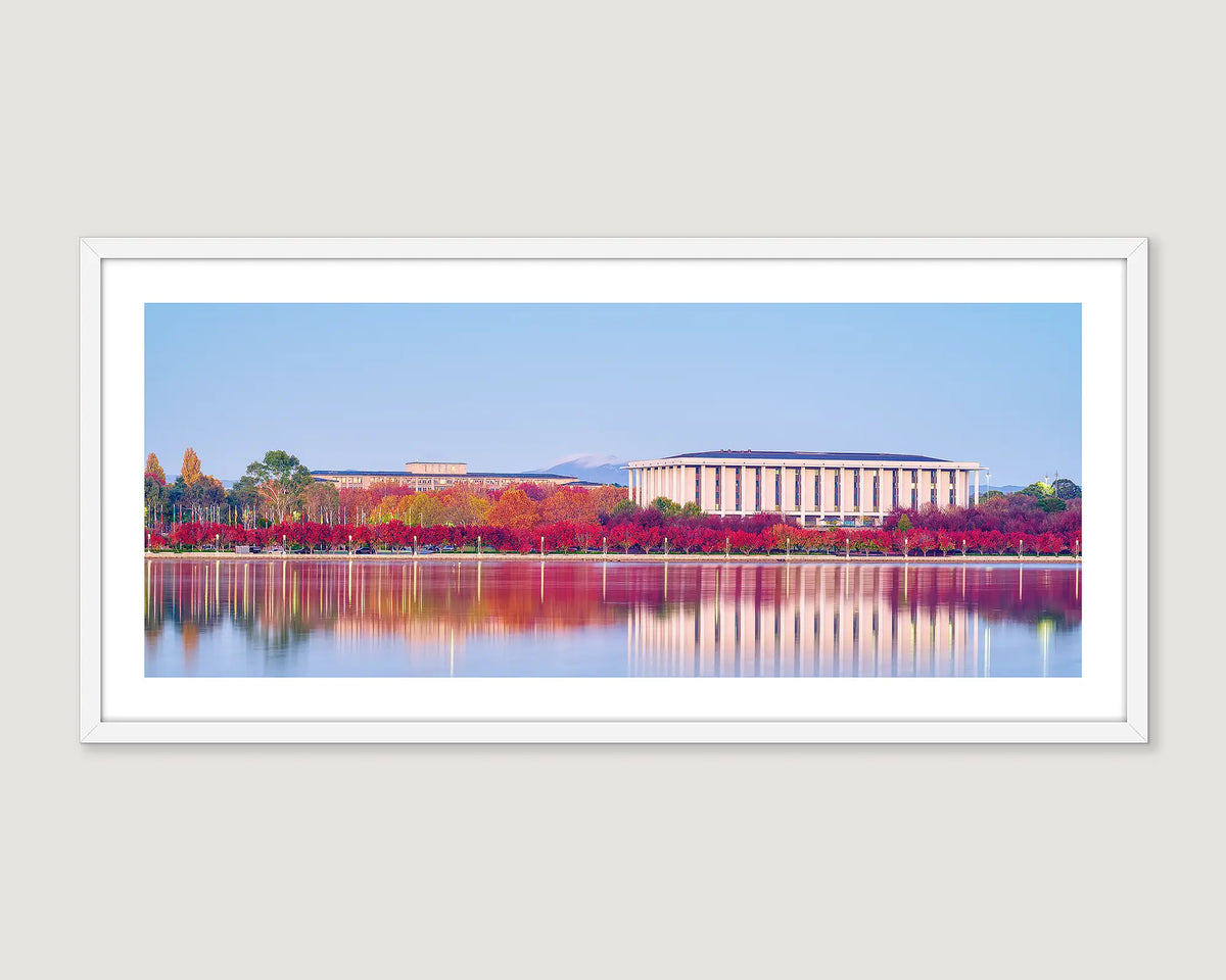 Framed photograph of The Treasury Building and The National Library Of Australia and red trees on the lake.