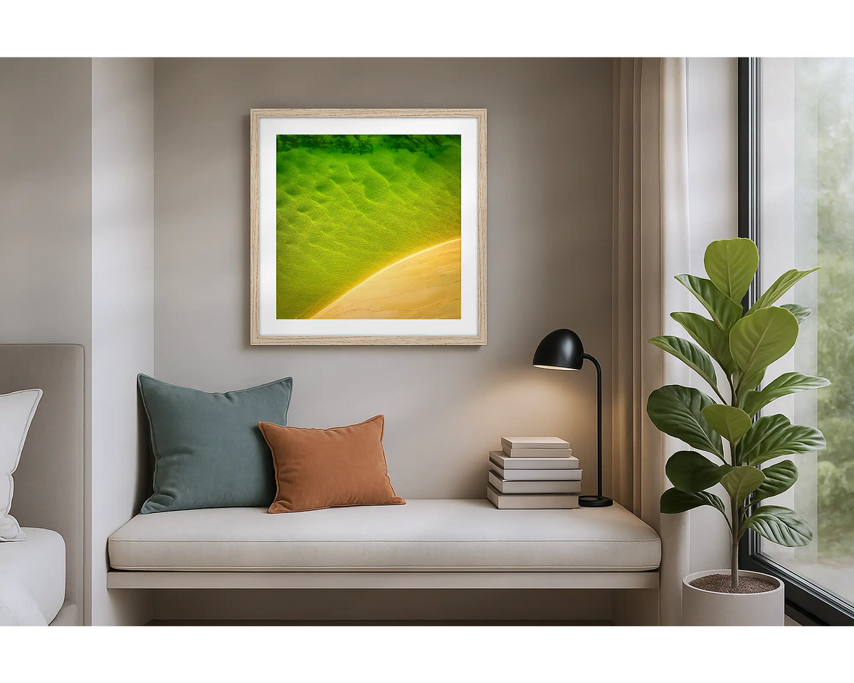 Mosaic. Aerial view of Durras Lake, wall art print in a timber frame hung in an apartment bedroom. 