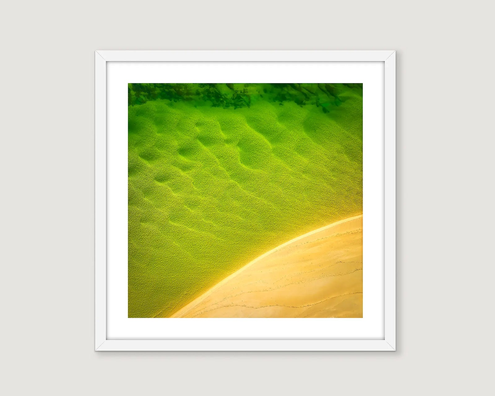 Framed abstract photograph of yellow sand and green waves.