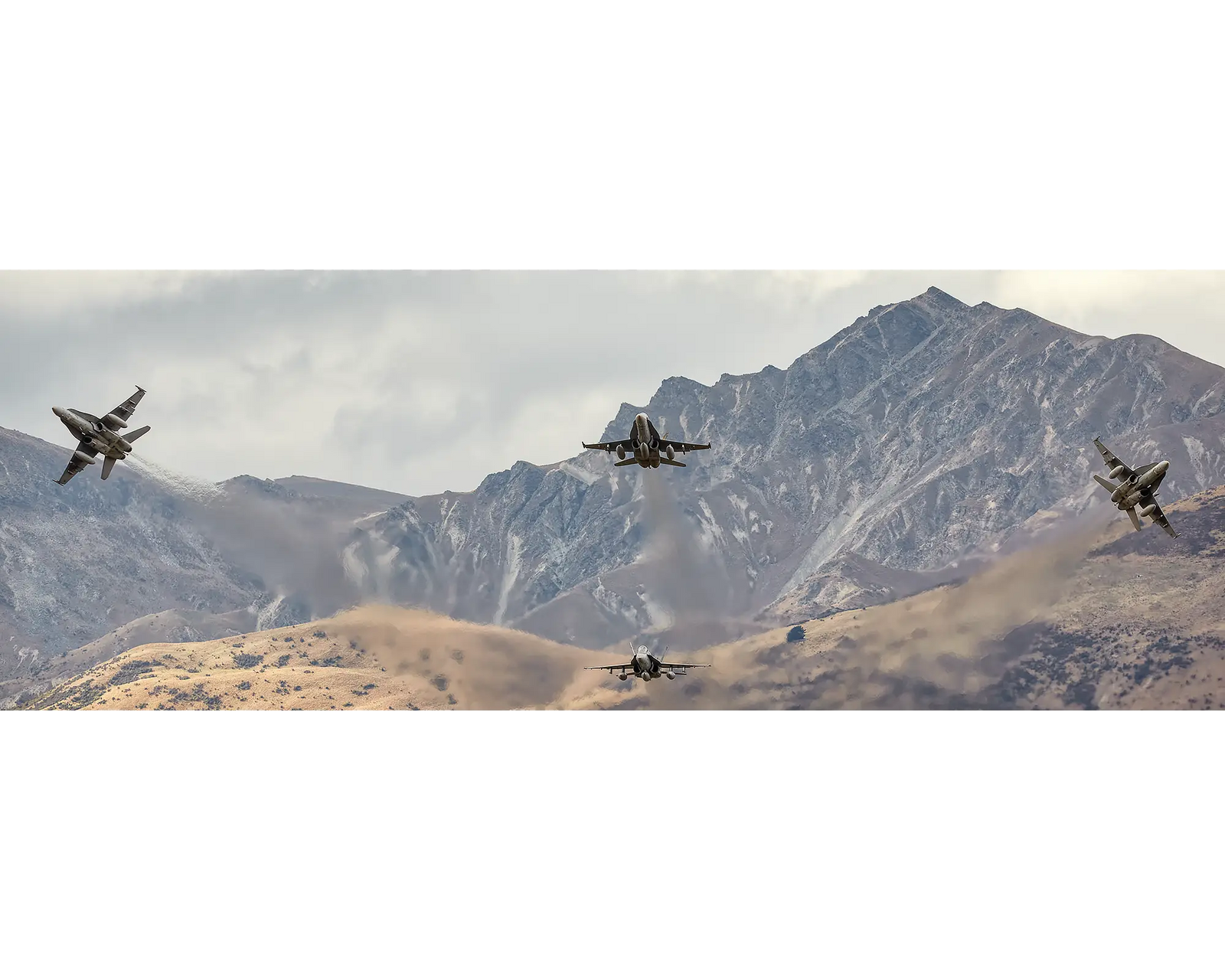 Royal Australian Air Force 3 squadron F/A-18 Hornets flying in front of a mountain range in New Zealand. 