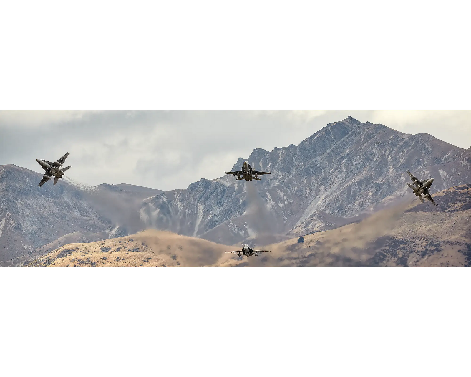 Mountain Bomb Burst. Royal Australian Air Force F/A-18 Hornets from 3 Squadron fly in front of New Zealand mountain range.