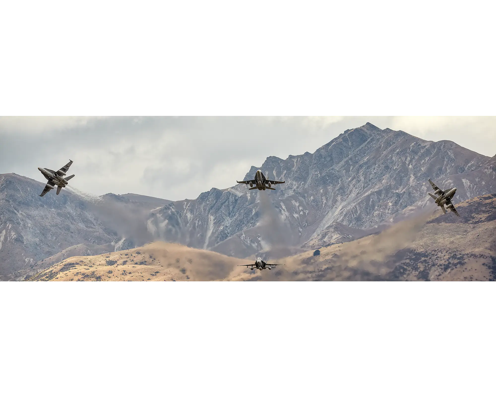 Mountain Bomb Burst. Royal Australian Air Force F/A-18 Hornets from 3 Squadron fly in front of New Zealand mountain range.