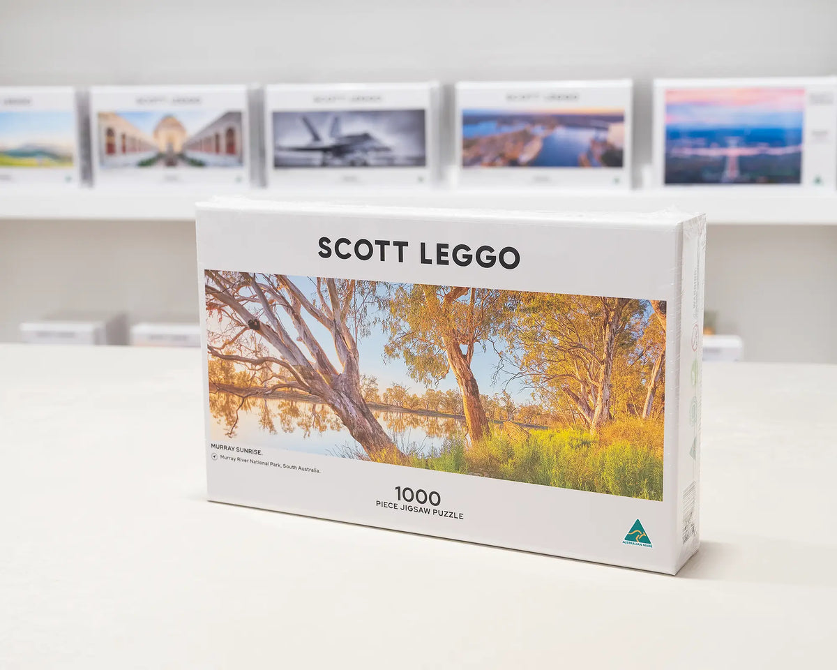 Murray Sunrise 1000 piece jigsaw puzzle sitting on desk in front of other puzzles.