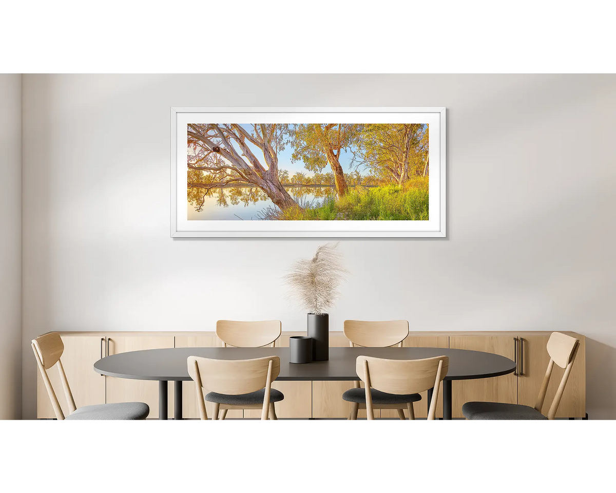 Murray Sunrise. Photographic wall art print of the Murray River at sunrise, framed in a white frame and hung on a dining room wall. 