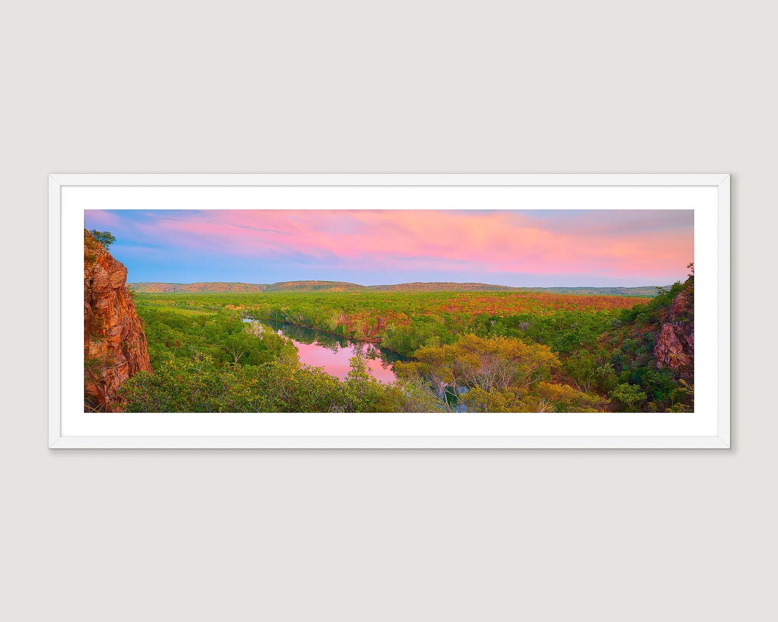 Framed landscape photograph of a gorge surrounded by trees and a pink and blue sunrise.
