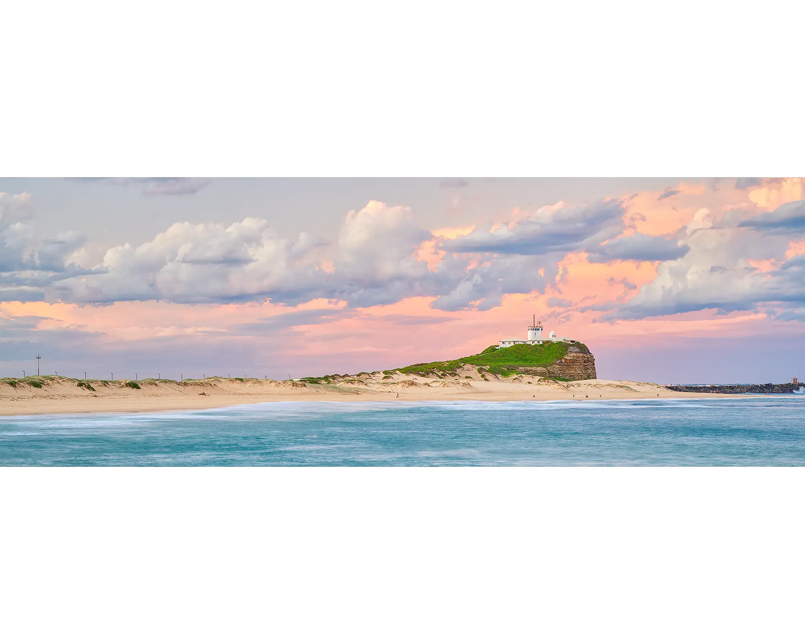 Newcastle Magic. Pink sunset over Nobbys Beach and lighthouse, Newcastle.