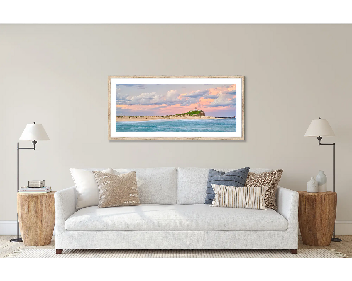 Newcastle Magic. Wall art print of a sunset over Nobby&#39;s Beach, Newcastle, framed with a timber frame and hung above a couch. 