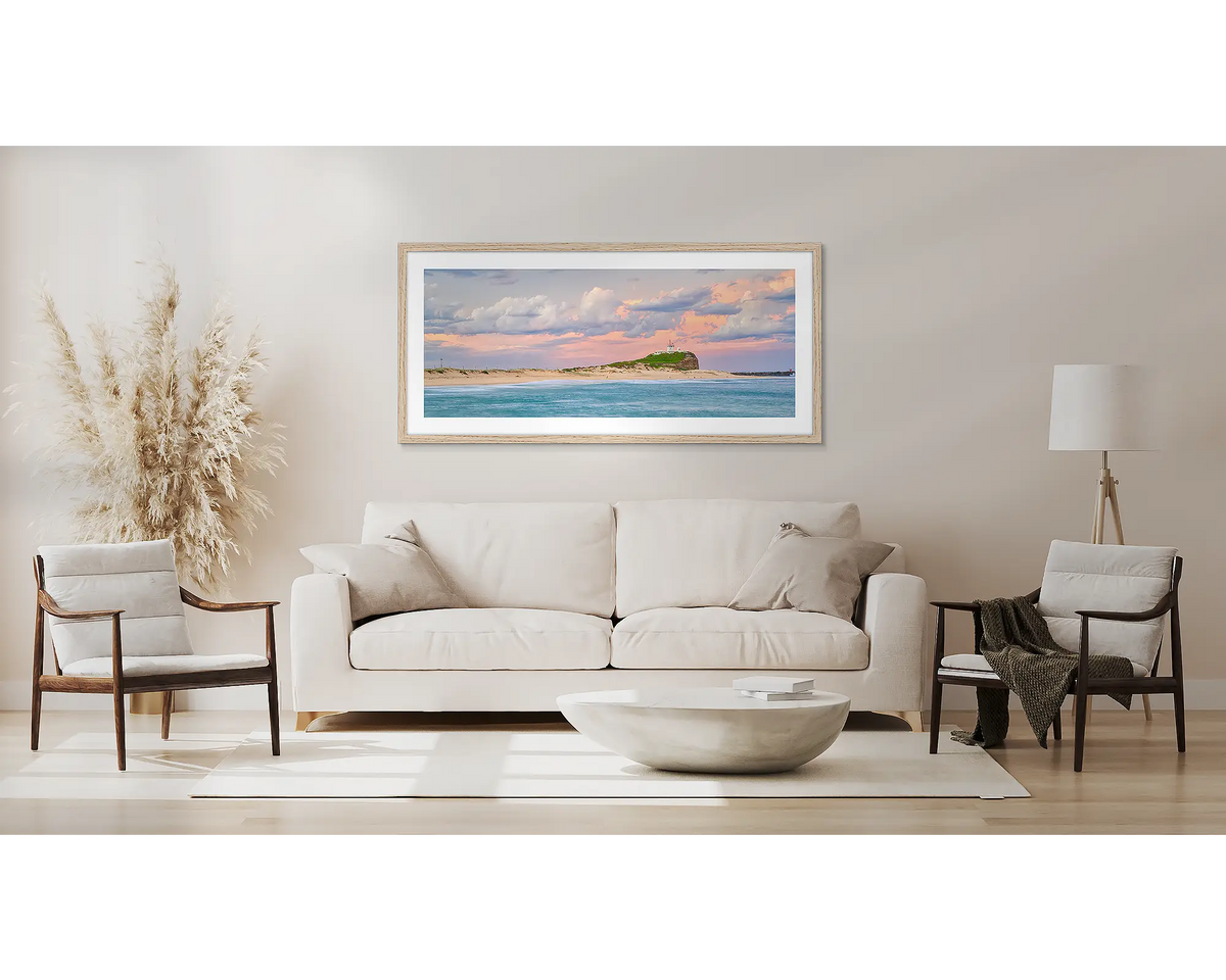 Newcastle Magic. Wall art print with a timber frame of sunset over Nobby&#39;s Beach Newcastle, hung above a couch.